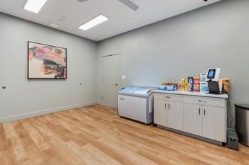 A room with a wooden floor and a painting on the wall.